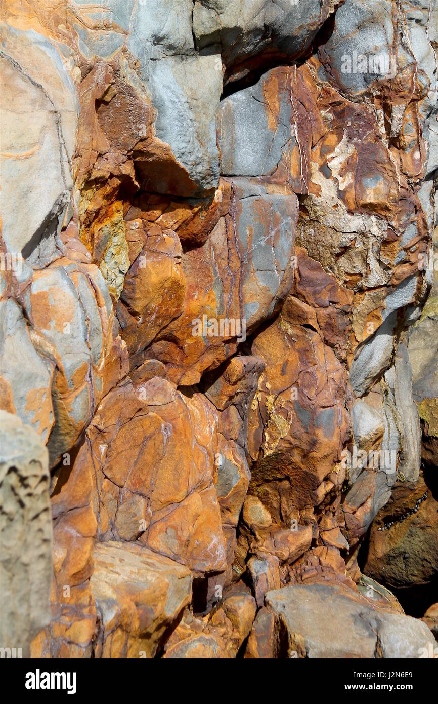 Ruggine rocce colorate sulla scogliera sul mare Foto Stock