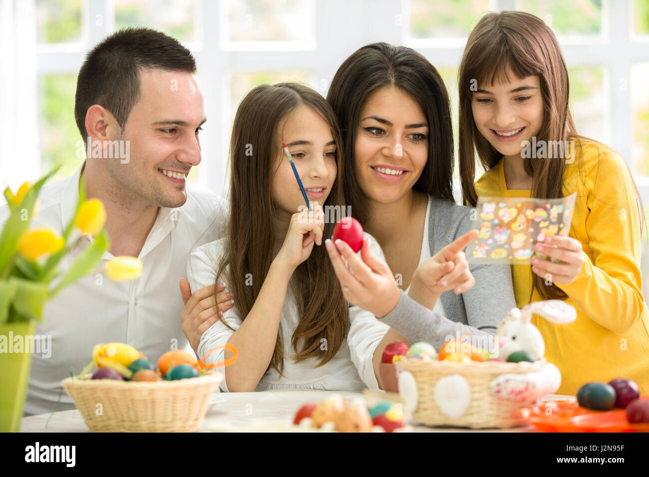 Felice Pasqua famiglia scegliendo un'immagine in miniatura per le uova Foto Stock