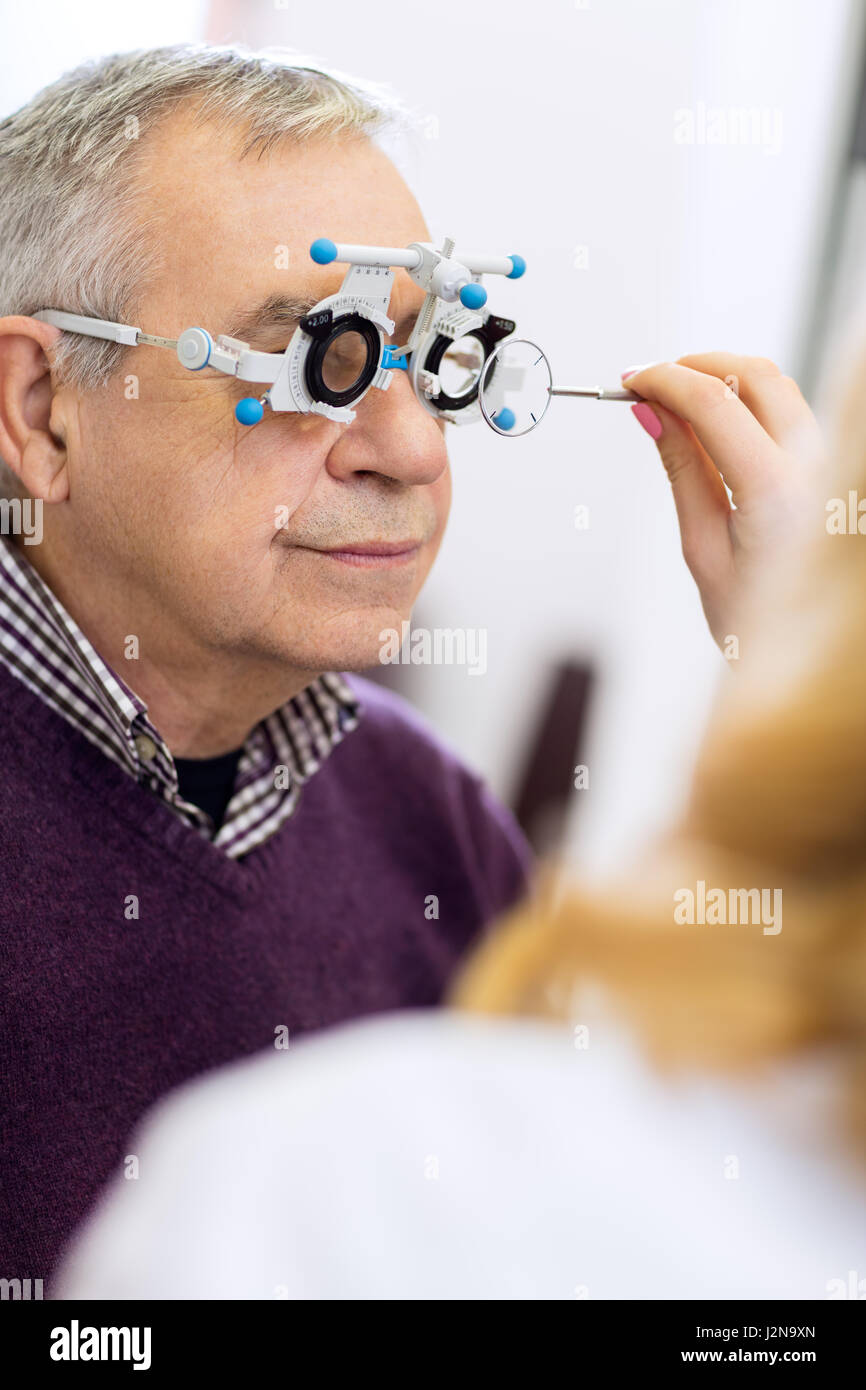 Medico oftalmica di misurare la distanza della pupilla degli occhi nella sala di consultazione Foto Stock