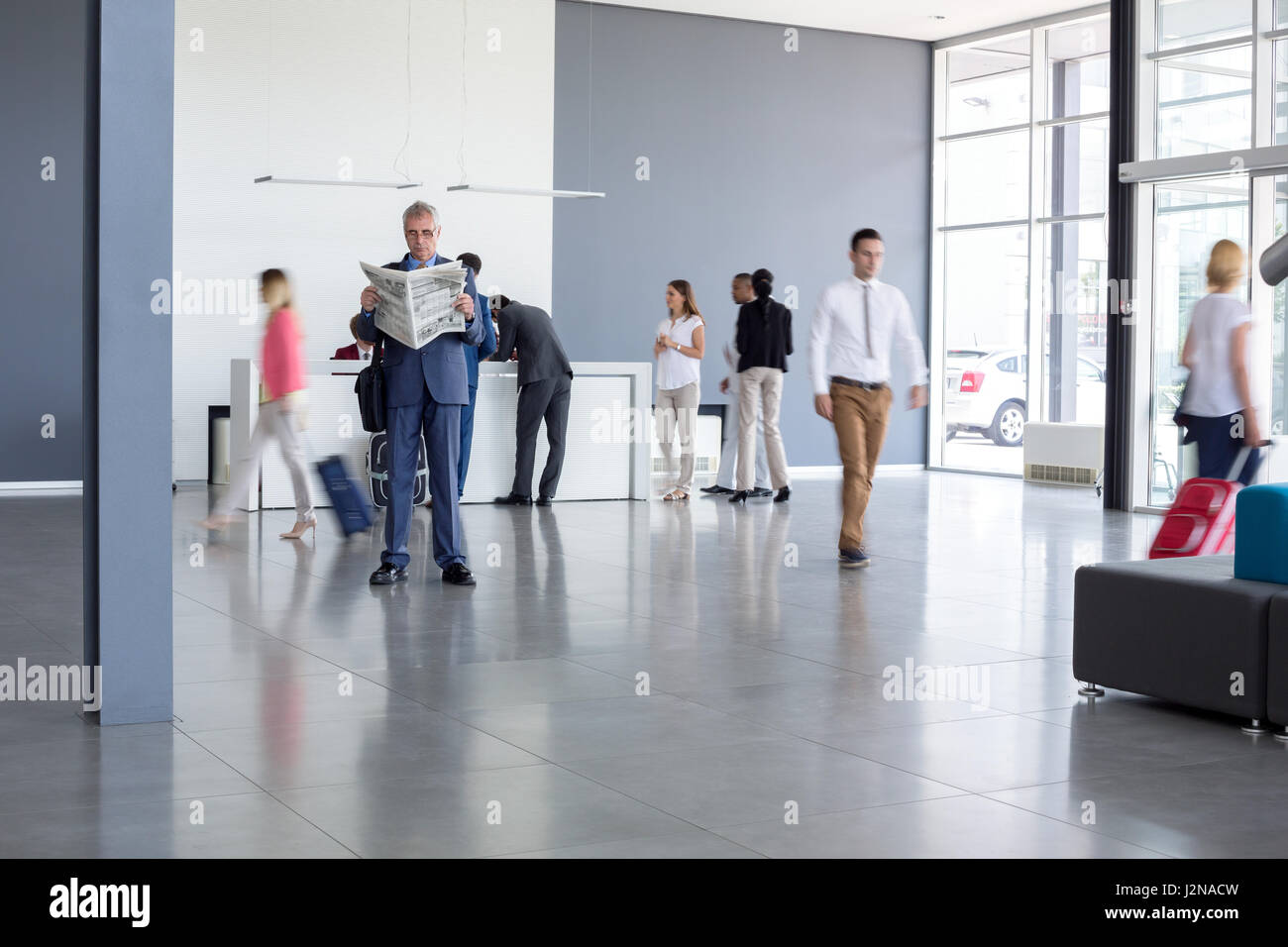 Uomo in eleganti abiti maschili leggere giornali su airport Foto Stock