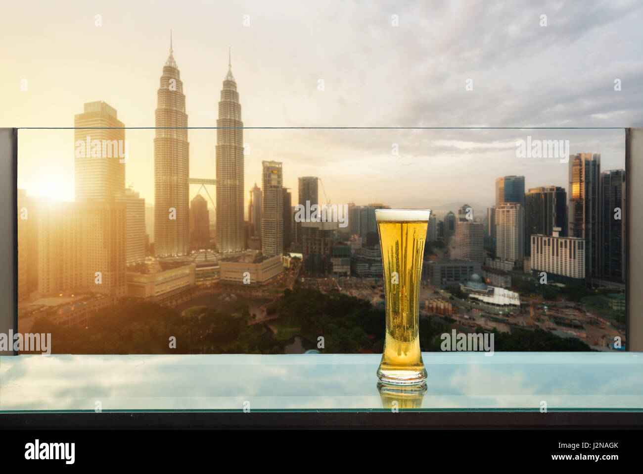 Birra e schiuma di birra sul tavolo in bar sul tetto con Kuala Lumpur grattacielo in background di Kuala Lumpur in Malesia. Foto Stock