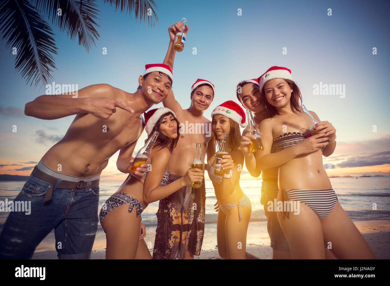 Giovani felici le persone sulla spiaggia avente Christmas party, vacanze natale Foto Stock