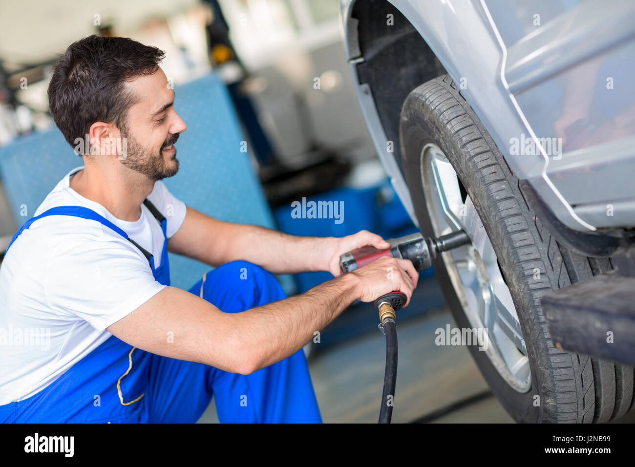 Cambio meccanico ruota su auto con chiave a percussione Foto Stock