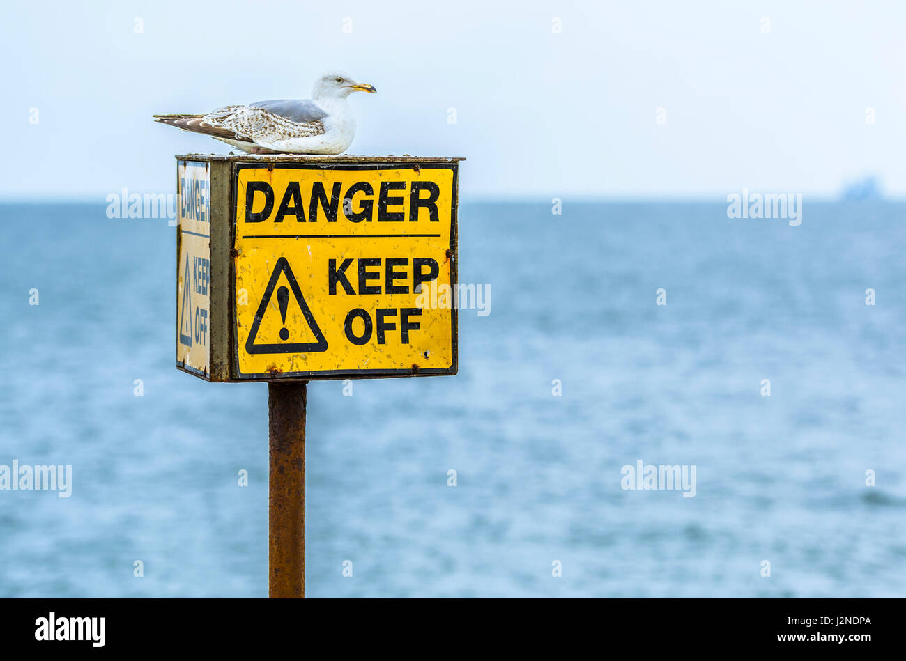 Pericolo tenere spento segno a rocce su una spiaggia. Foto Stock