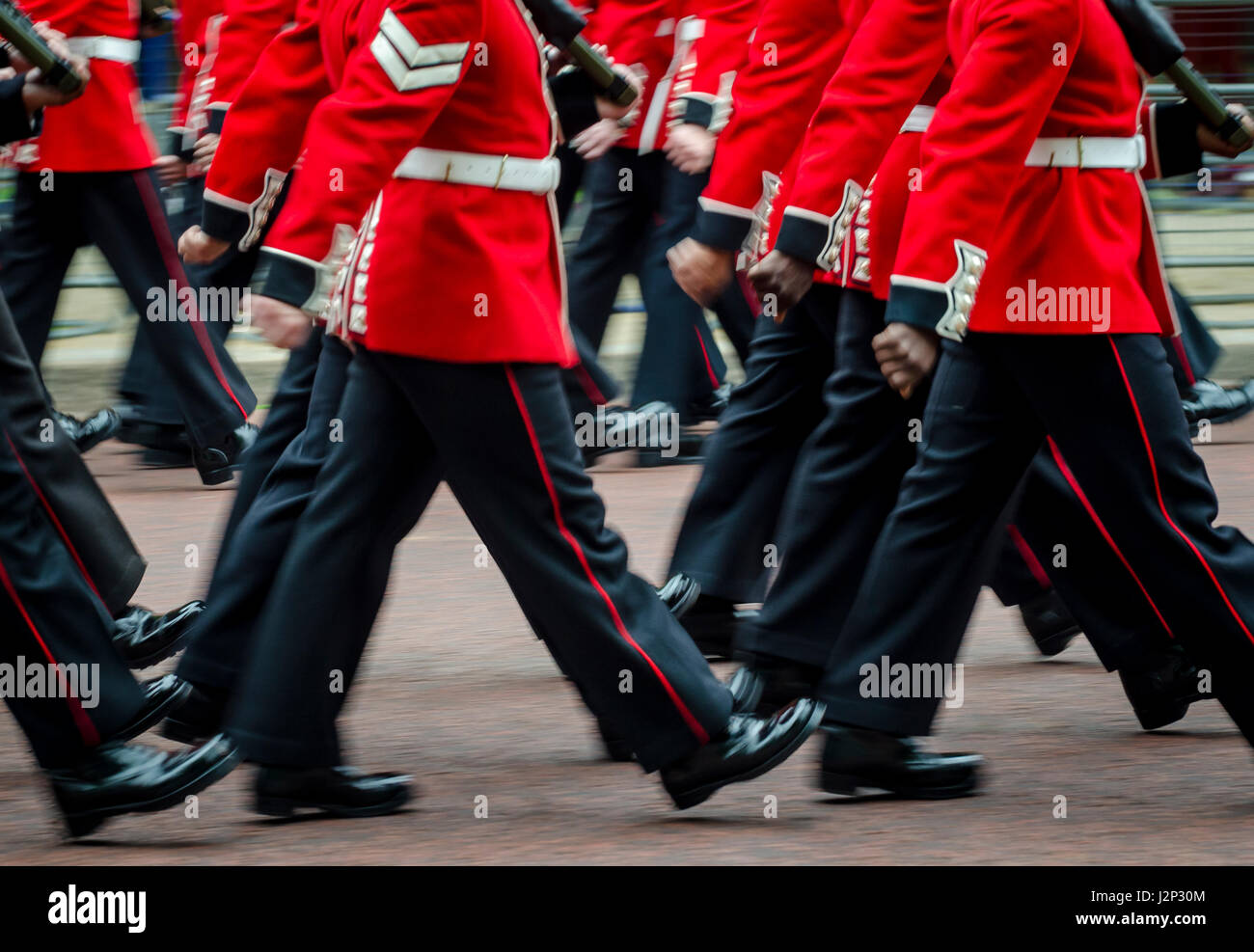 Red giacche e pantaloni neri del reggimento in uniforme della Regina della Guardia Reale marciando in una cerimonia sul Mall a Londra in Inghilterra Foto Stock