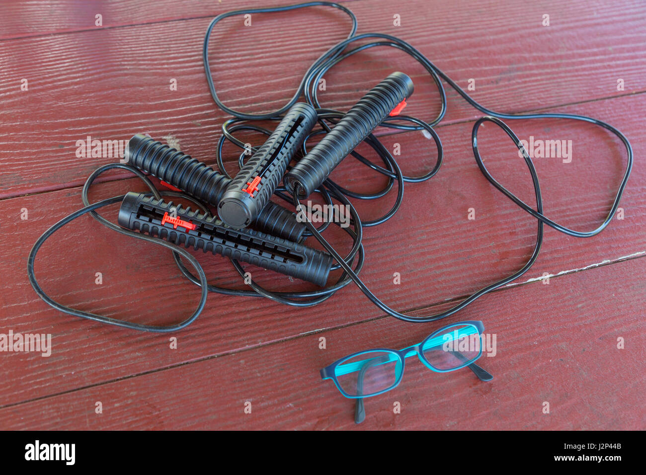 Due serie di funi di salto e di un paio di occhiali sul vecchio tavolo in legno Foto Stock