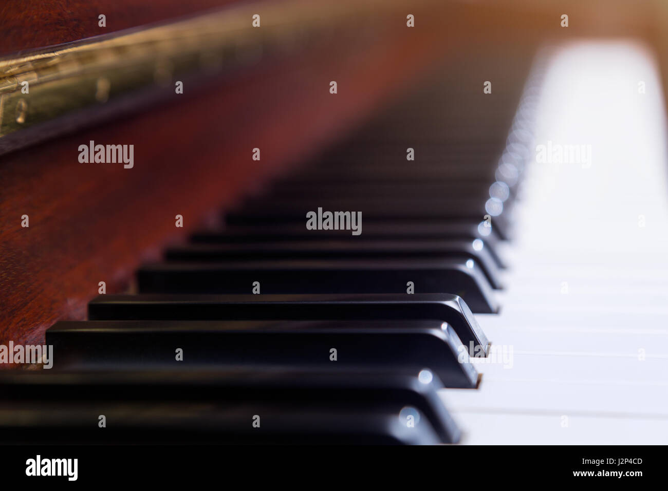 Tasti di pianoforte in profondità di campo e messa a fuoco selettiva su un tasto nero, blur sullo sfondo, vintage effetto di illuminazione Foto Stock