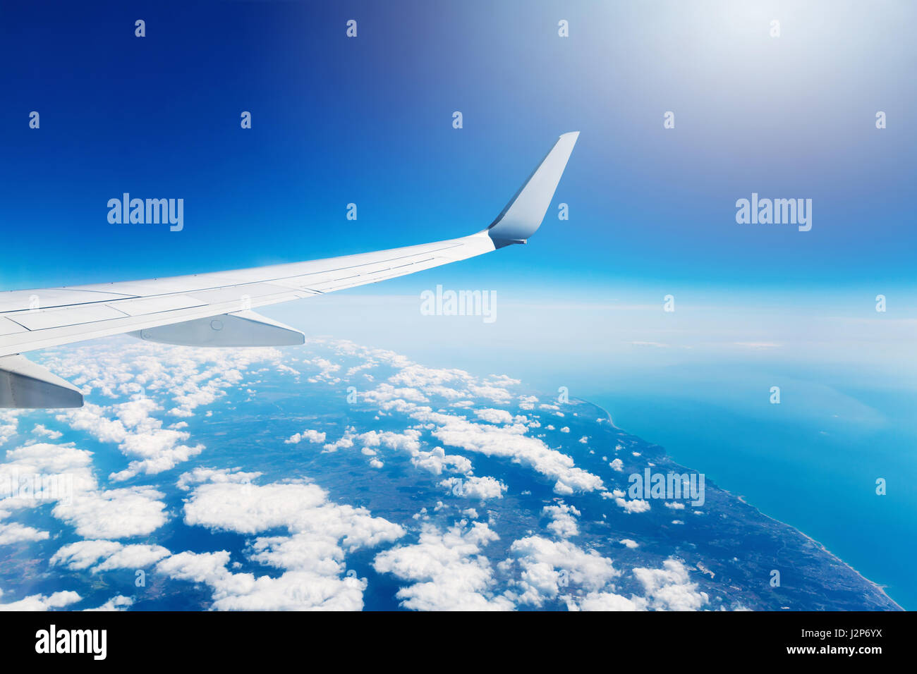Ala di un aeroplano che vola in alto nel cielo sopra le nuvole Foto Stock