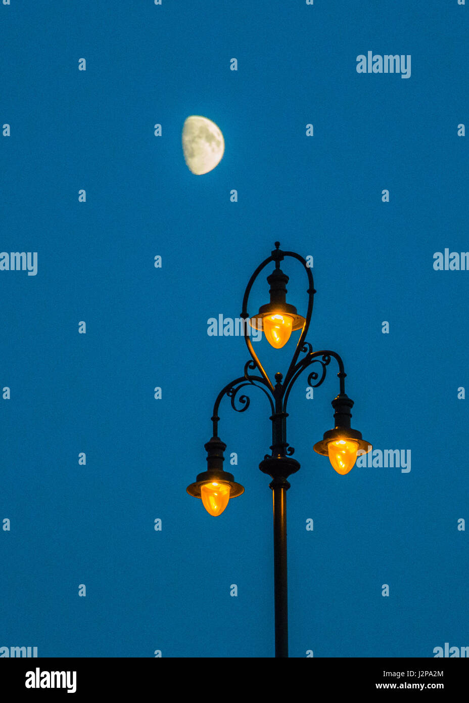 Un lampione con la luna al blue ora Foto Stock