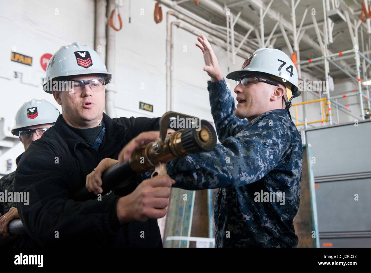 170420-N-ZH960-080 BREMERTON nello Stato di Washington (20 aprile 2017) dell'aviazione di Boatswain Mate (manipolazione) 1a classe Ronald Warren e aviazione di Boatswain Mate (manipolazione) 1a classe Jack condotta Bridgeman manichetta antincendio formazione di manipolazione durante un quartieri generali della seminatrice nel USS John C. Stennis' (CVN 74) hangar bay. John C. Stennis sta conducendo una prevista disponibilità incrementale (PIA) a Puget Sound Naval Shipyard e Manutenzione intermedia Facility, durante il quale la nave sta subendo una manutenzione pianificata e aggiornamenti. (U.S. Foto di Marina di Massa Specialista comunicazione di seconda classe P. Andrew Holmes / rilasciato) Foto Stock