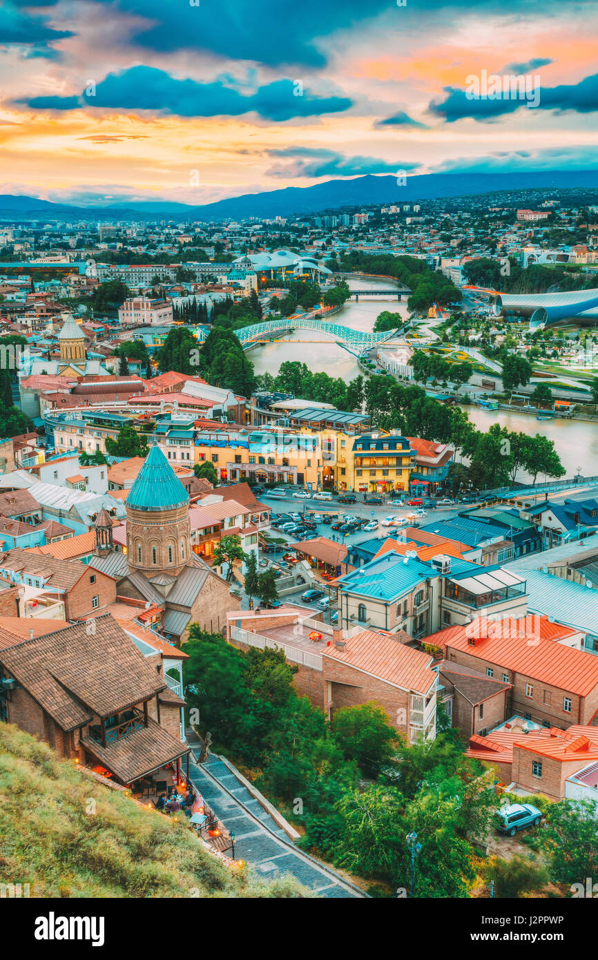 Vista superiore della vecchia città colorate e Kura fiume Mtkvari sotto i ponti in estate Tbilisi, Georgia Beautiful Scenic Sunset Sunrise Alba cielo nuvoloso indietro Foto Stock