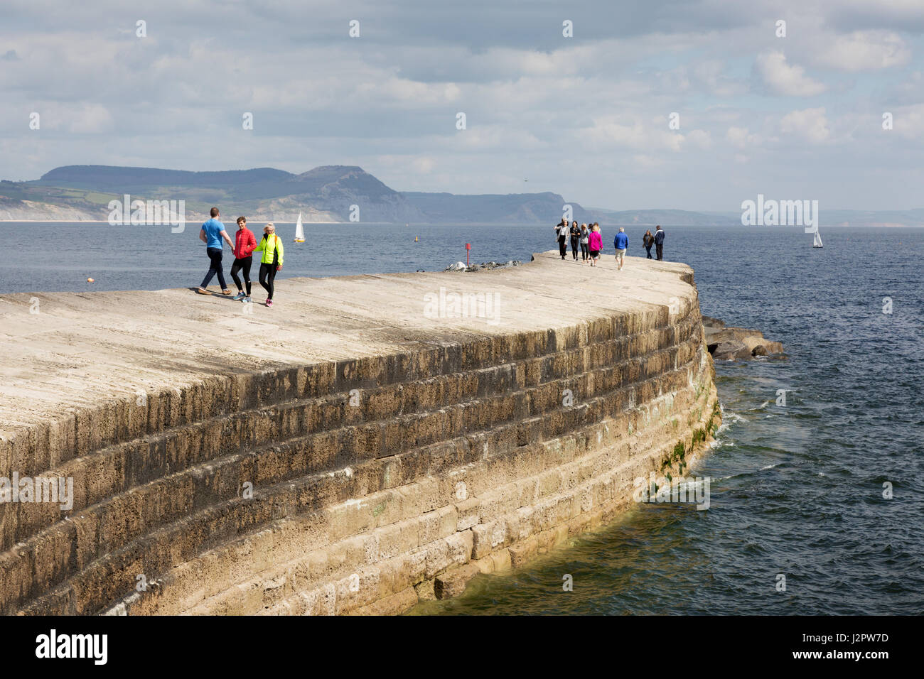 Lyme Regis Cobb Dorset - la gente che camminava sul Cobb, o parete di porto, Lyme Regis Harbour, Lyme Regis Dorset Regno Unito Foto Stock