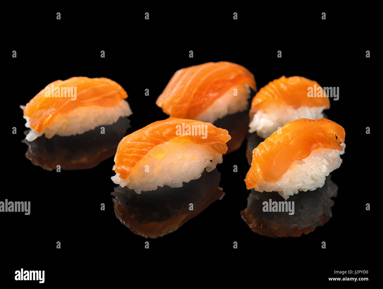 I sushi giapponesi La cucina del nigiri con salmone isolati su sfondo nero con la riflessione, close up, il concetto di uno stile di vita sano Foto Stock