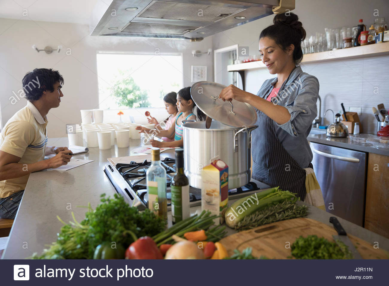 Famiglia preparare il brodo vegetale in cucina Foto Stock