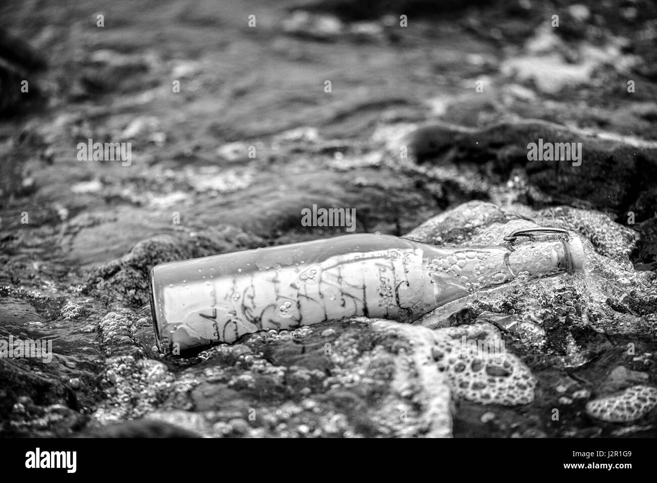 Lavata dal mare vecchia bottiglia con un messaggio. Foto Stock