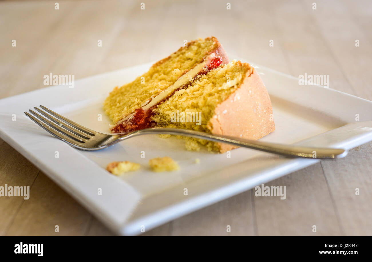 Cibo Victoria Sponge Cake parzialmente mangiato il Dessert budino di trattare dolce cotto al forno di cottura piastra forcella pomeriggio relax trattare indulgenza Foto Stock