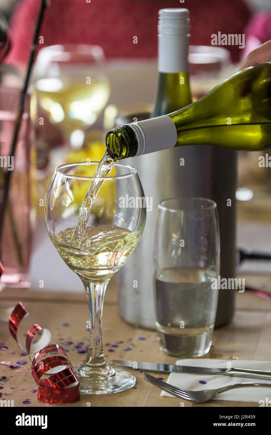 Vino bianco versata in un bicchiere di alcool di vino di colata di vetro il consumo di alcool bere il vino Ristoranti Foto Stock