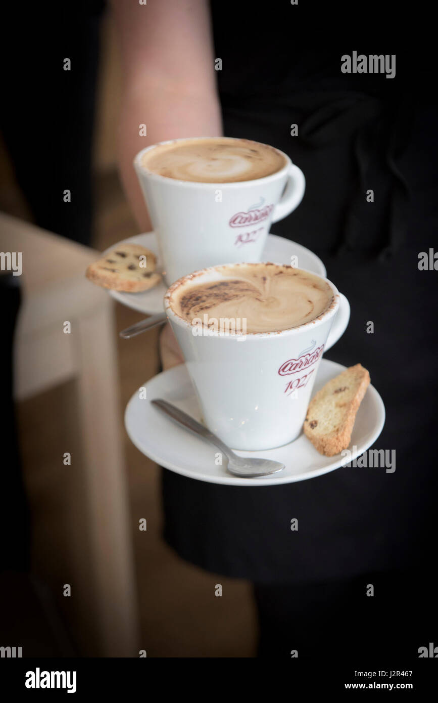 Ristorante interno servizio cameriera due cappuccini bevanda caffè pausa caffè caffè tempo essendo servita Foto Stock