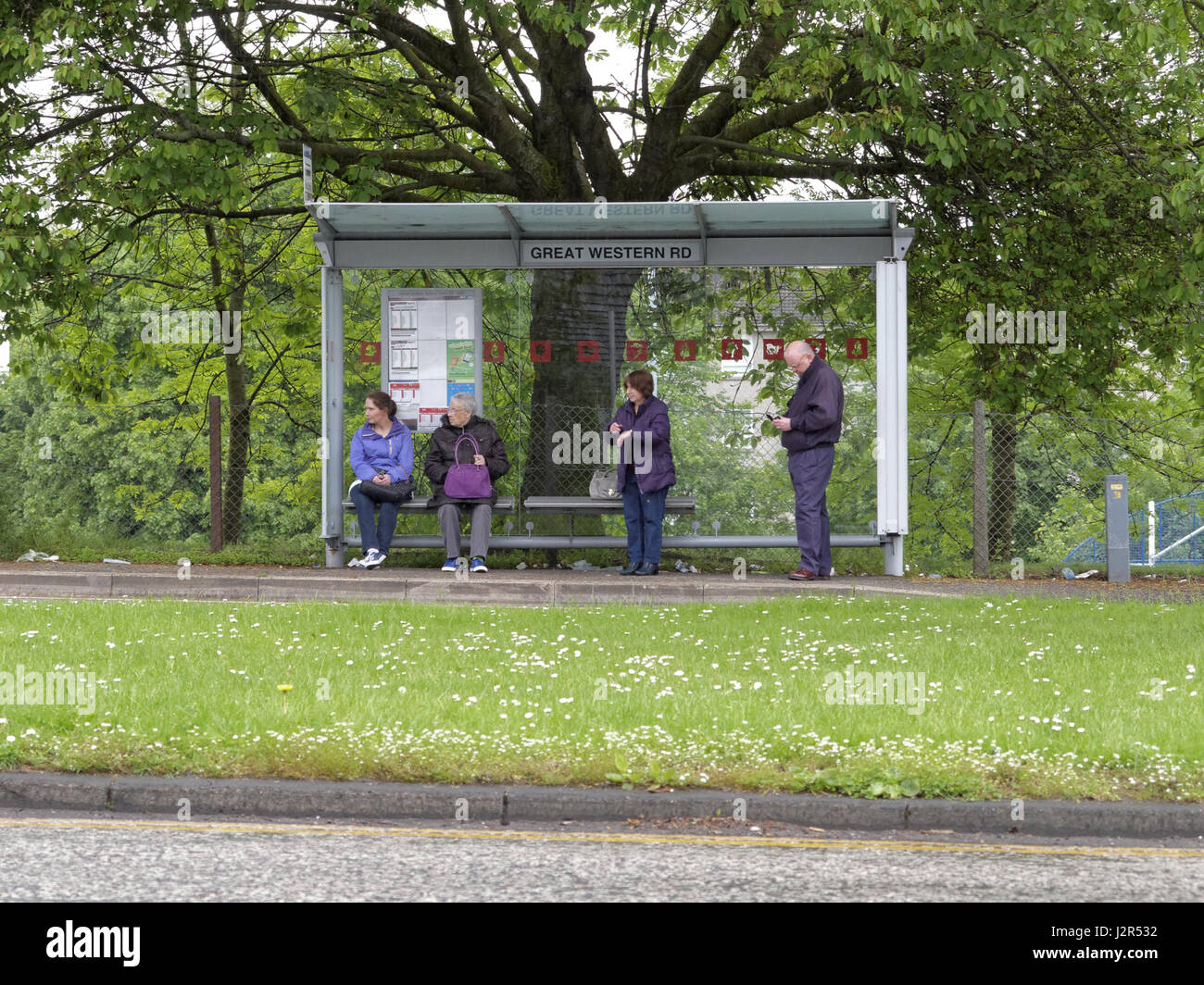 Fermata bus a Glasgow Great Western Road con i passeggeri di carattere locale Foto Stock