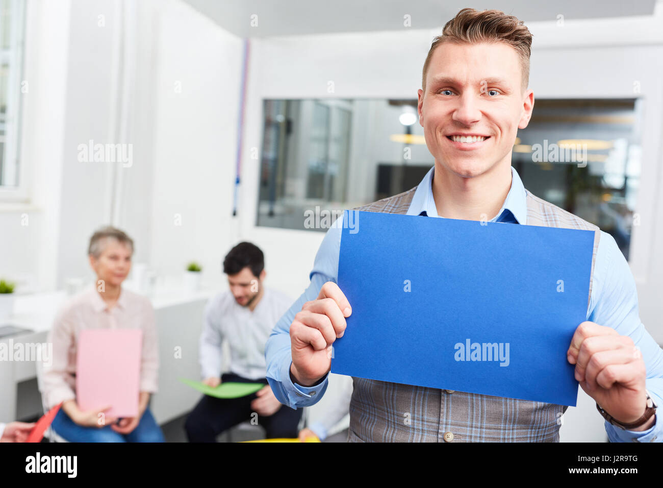 Giovani start-up uomo detiene pagina vuota durante il brainstorming creativo in ufficio Foto Stock