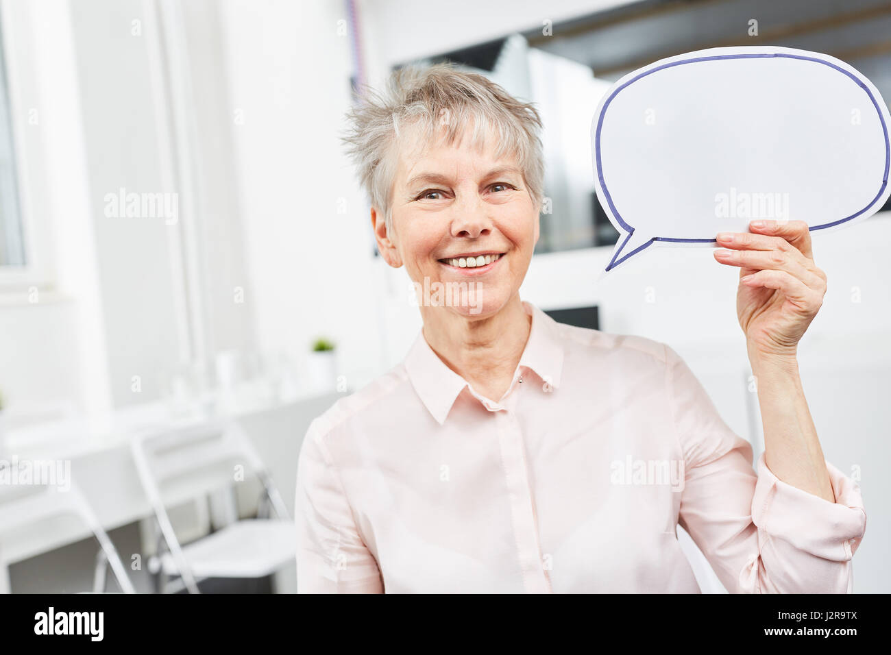 Senior business donna con discorso bolla come concetto di comunicazione Foto Stock