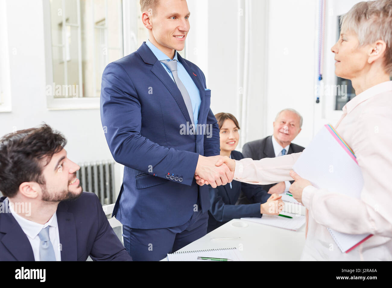 Senior imprenditrice condividere handshake con partecipante come segno di congratulazioni Foto Stock