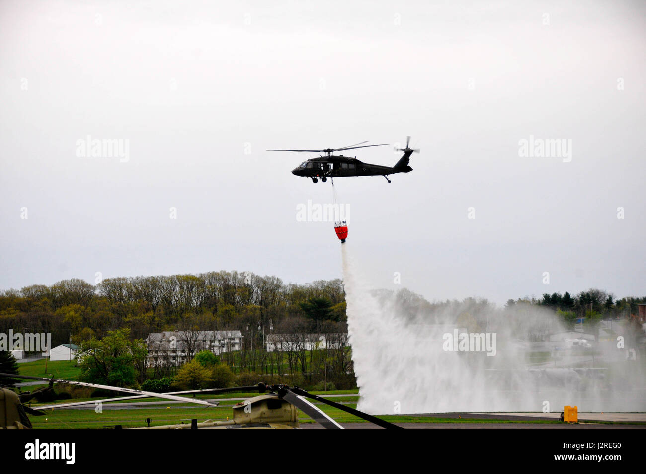 Soldati con Alfa Company, 2-104th supporto generale del battaglione di aviazione, 28 Combattere la Brigata Aerea condotta secchio di acqua della formazione in un UH-60 Black Hawk elicottero a Fort Indiantown Gap, Aprile 22, 2017. 28 soldati della cabina sono abili in questa manovra che viene eseguita per estinguere gli incendi. Foto Stock