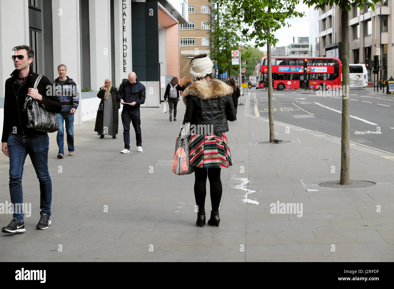 Moda giovane donna a piedi lungo Aldgate High Street in direzione di Whitechapel di East London EC3 UK KATHY DEWITT Foto Stock