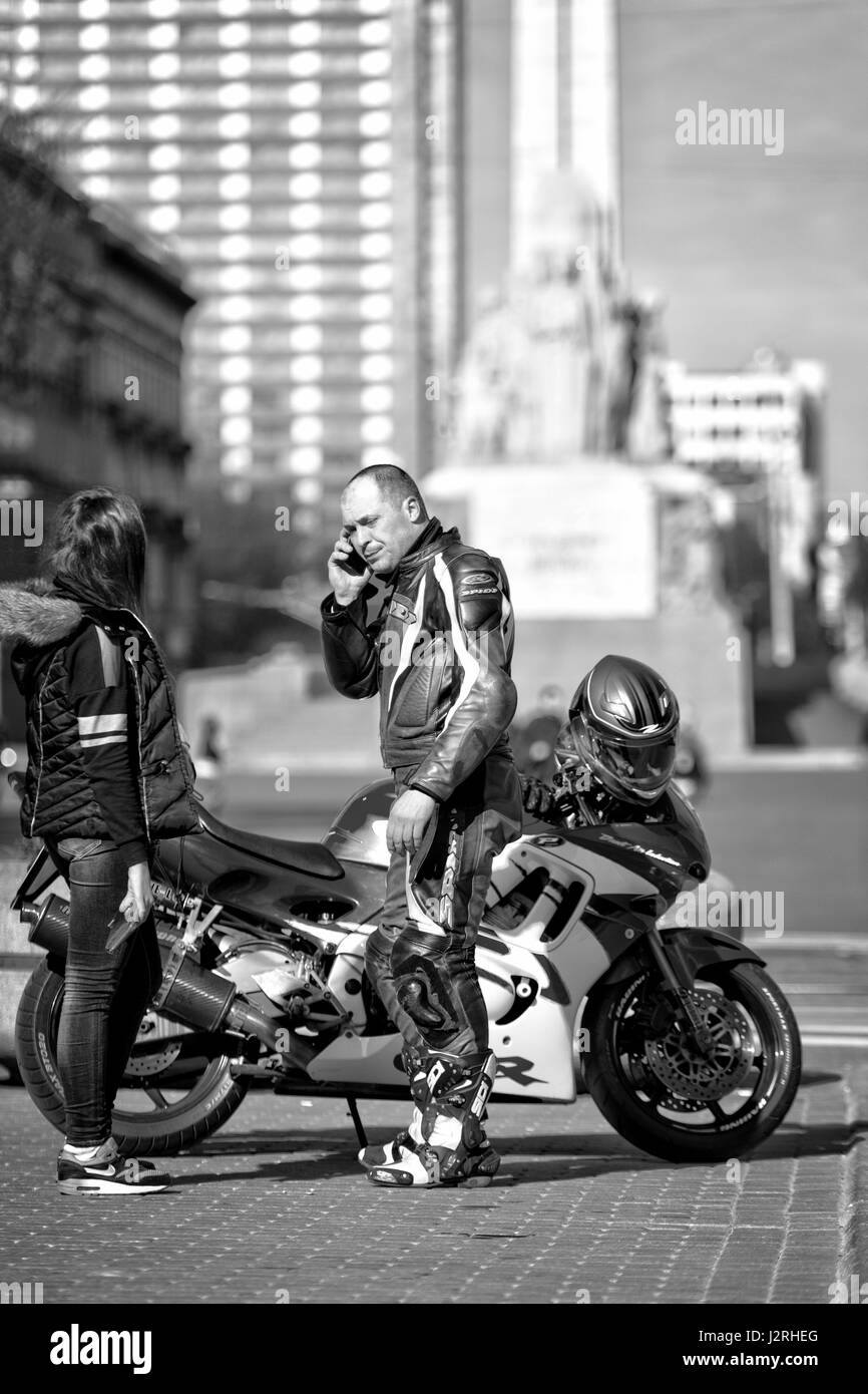 RIGA, Lettonia - 22 Aprile 2015: Sconosciuto uomo sulla strada in bicicletta per parlare al telefono. Foto Stock