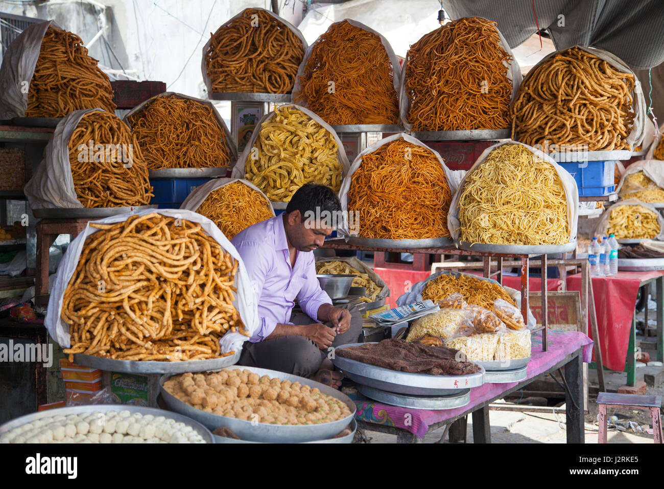 Un uomo seduto al suo negozio nel mercato a Amer vicino a Jaipur nel Rajasthan, India. Foto Stock