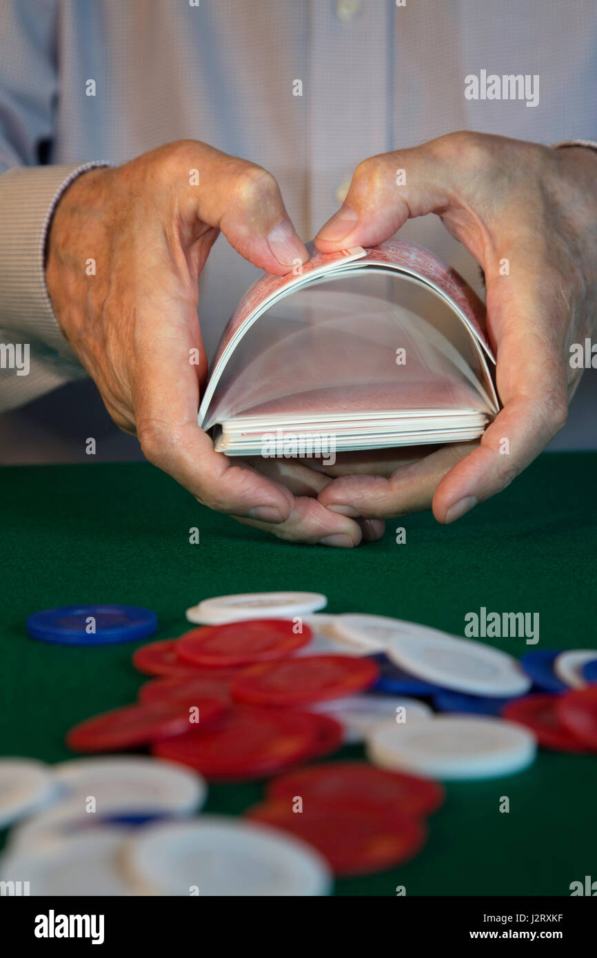 L'uomo rimescolare le carte di fronte al gioco di Poker Foto Stock