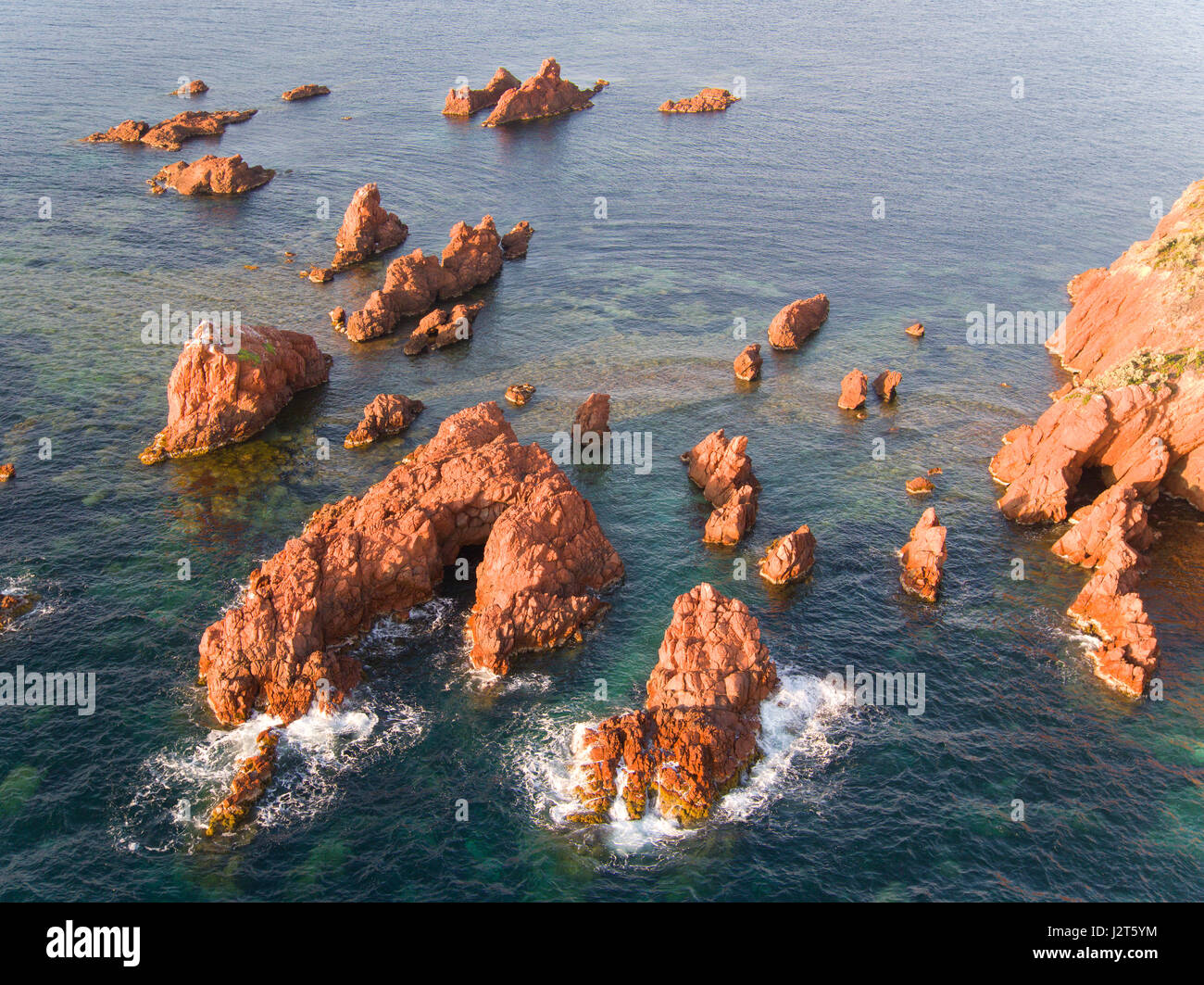 VISTA AEREA. Numerosi pinnacoli marini al largo della costa del Massiccio Esterel. Saint-Raphaël, Var, Costa Azzurra, Francia. Foto Stock