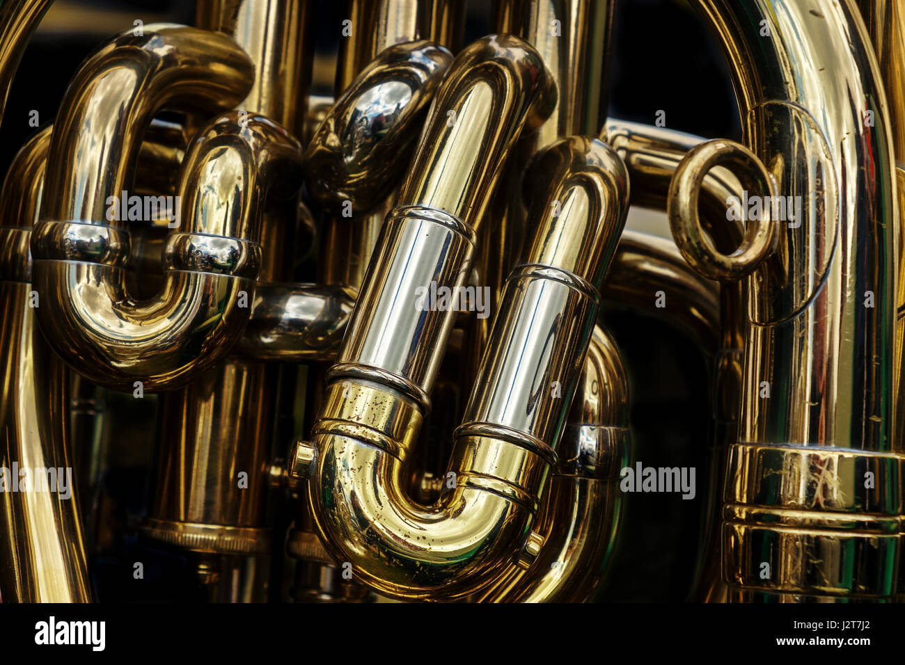 Dettaglio dei tubi di ottone di tuba. Abstract sfondo mostrante le curve e giunti di questo ottone lucidato fascia strumento musicale. Foto Stock