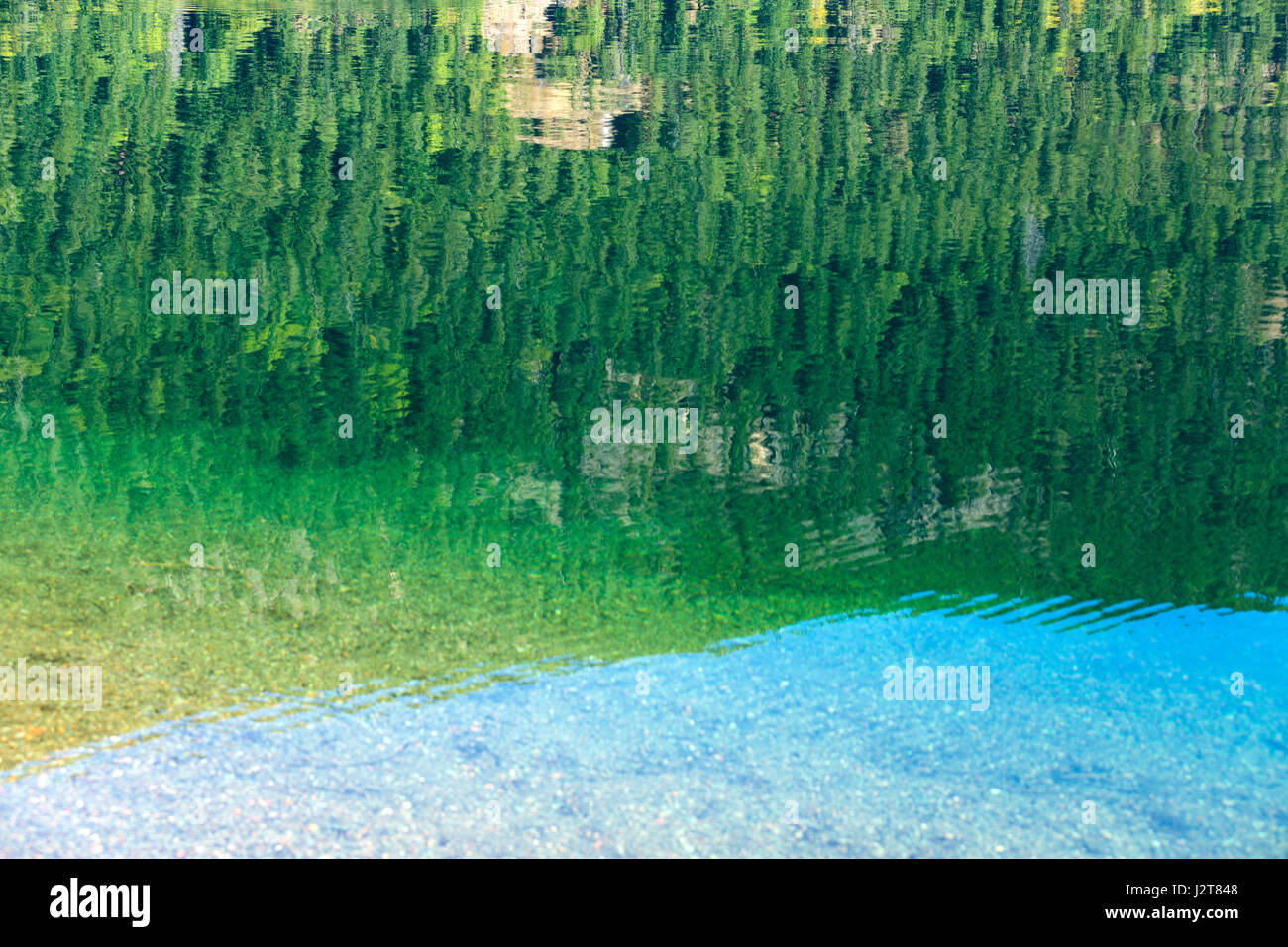 La riflessione nella calma, acque turchesi del lago di Cameron, Isola di Vancouver, Canada Foto Stock