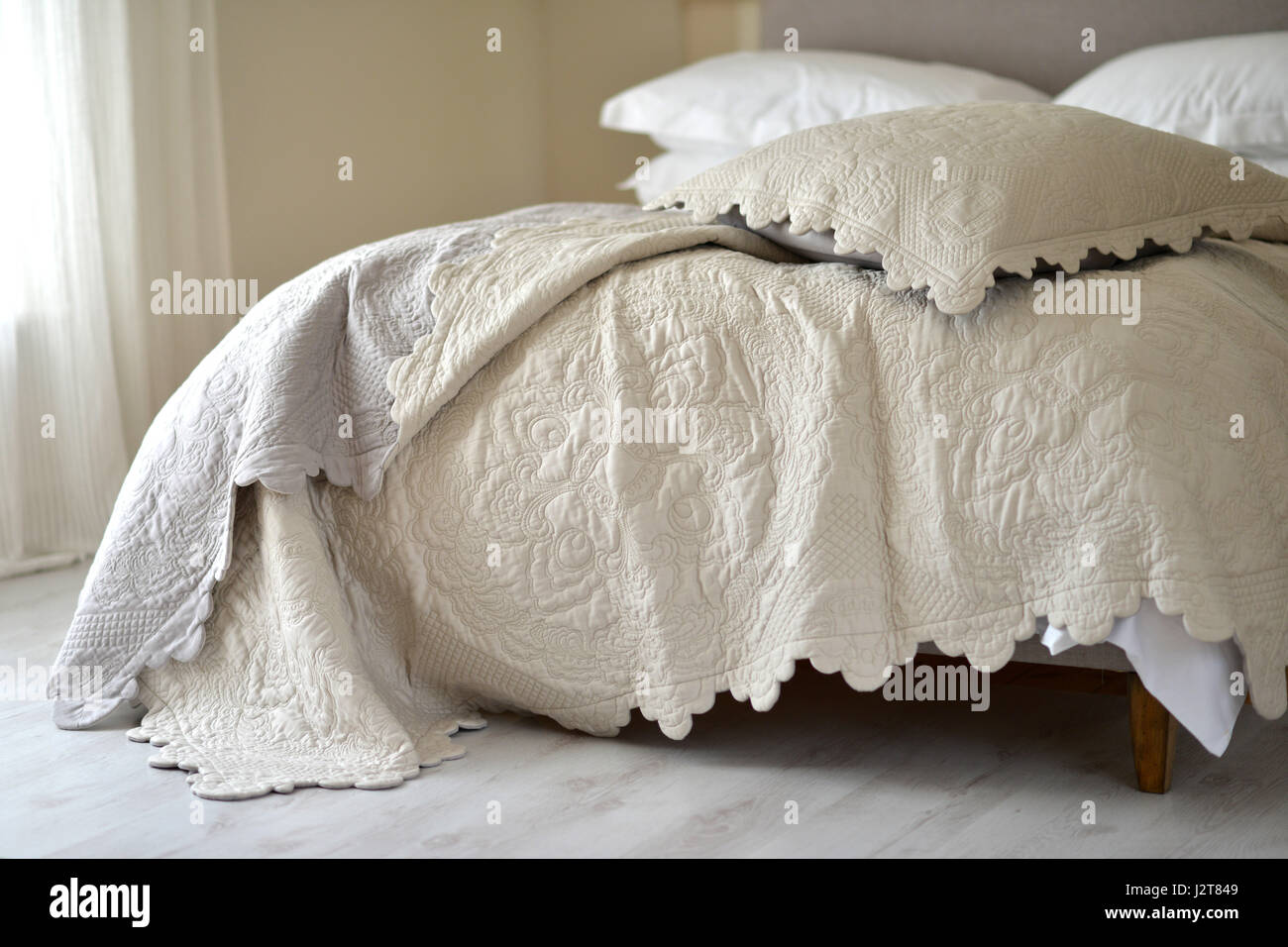 Copriletto di lusso sul letto disfatto. Foto Stock