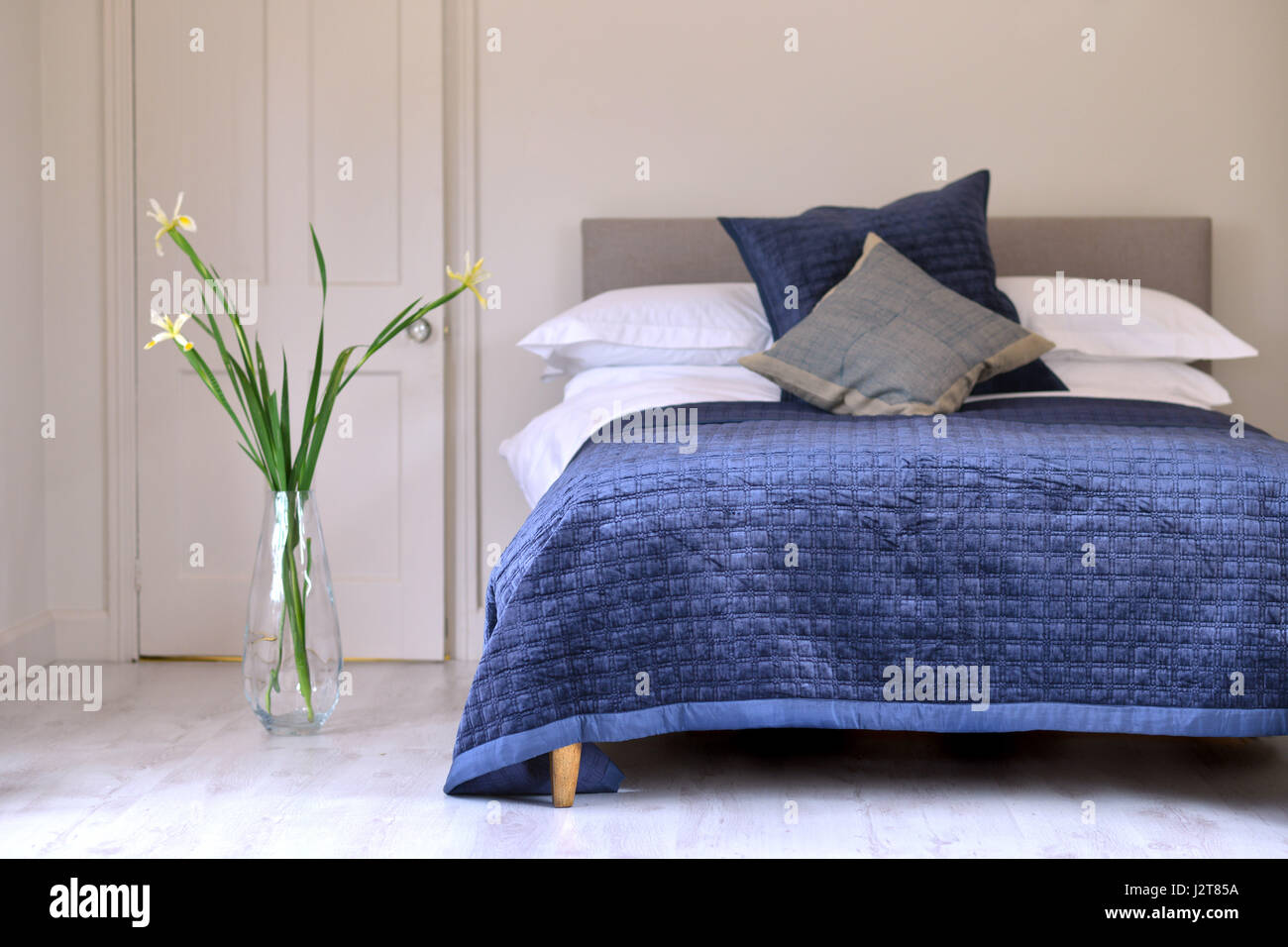 Camera da letto e un letto matrimoniale con trapunta blu Foto Stock