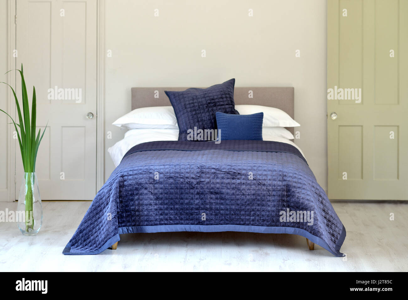 Camera da letto e un letto matrimoniale con trapunta blu Foto Stock