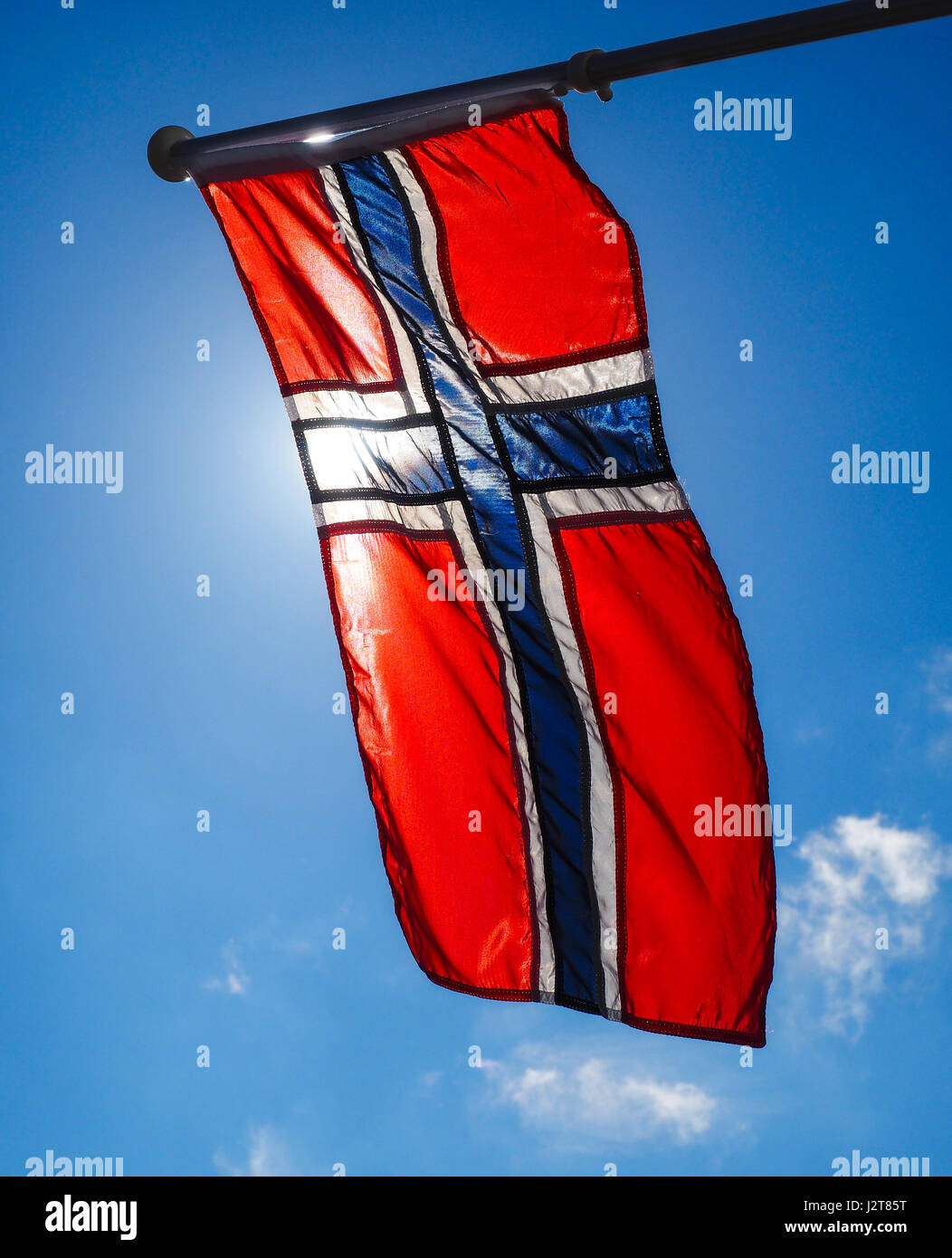 Bandiera norvegese fino vicino, verso il sole sul bel cielo azzurro Foto Stock