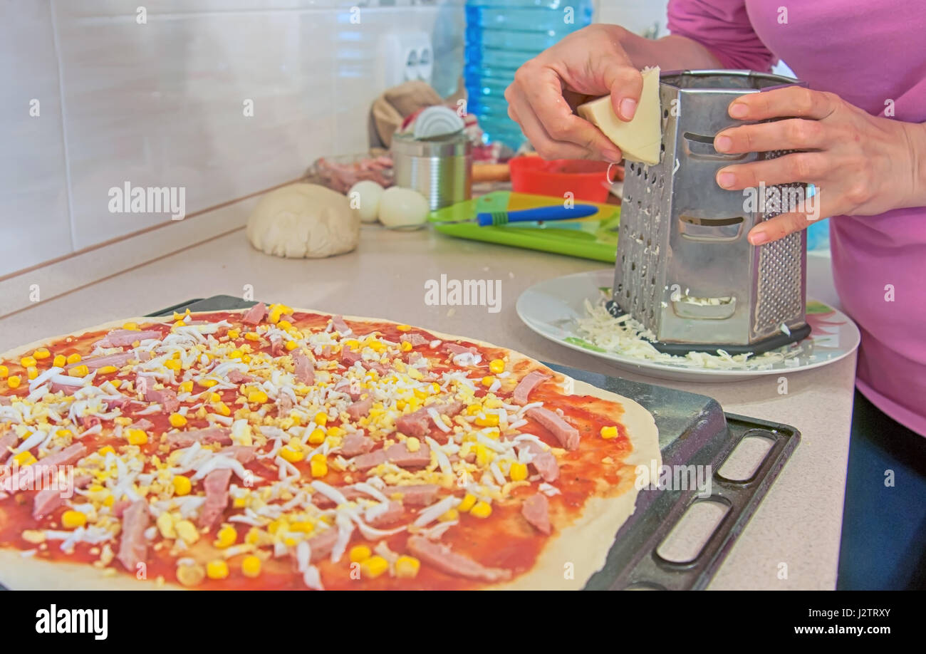 Donna preparare la pizza in cucina Foto Stock