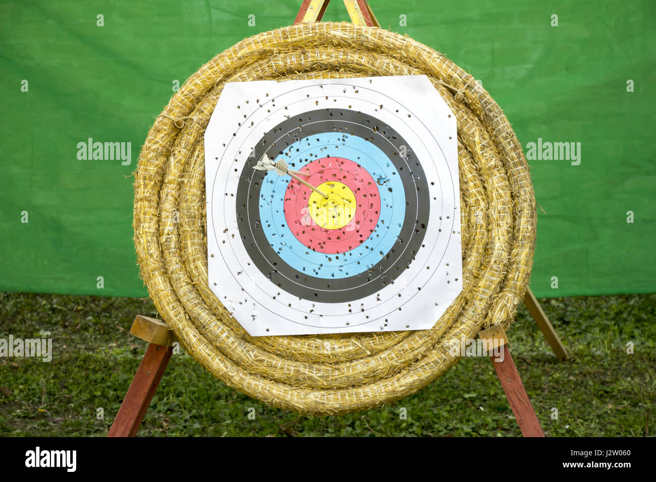 Tiro con l'arco Target con frecce su un sfondo di paglia Foto Stock