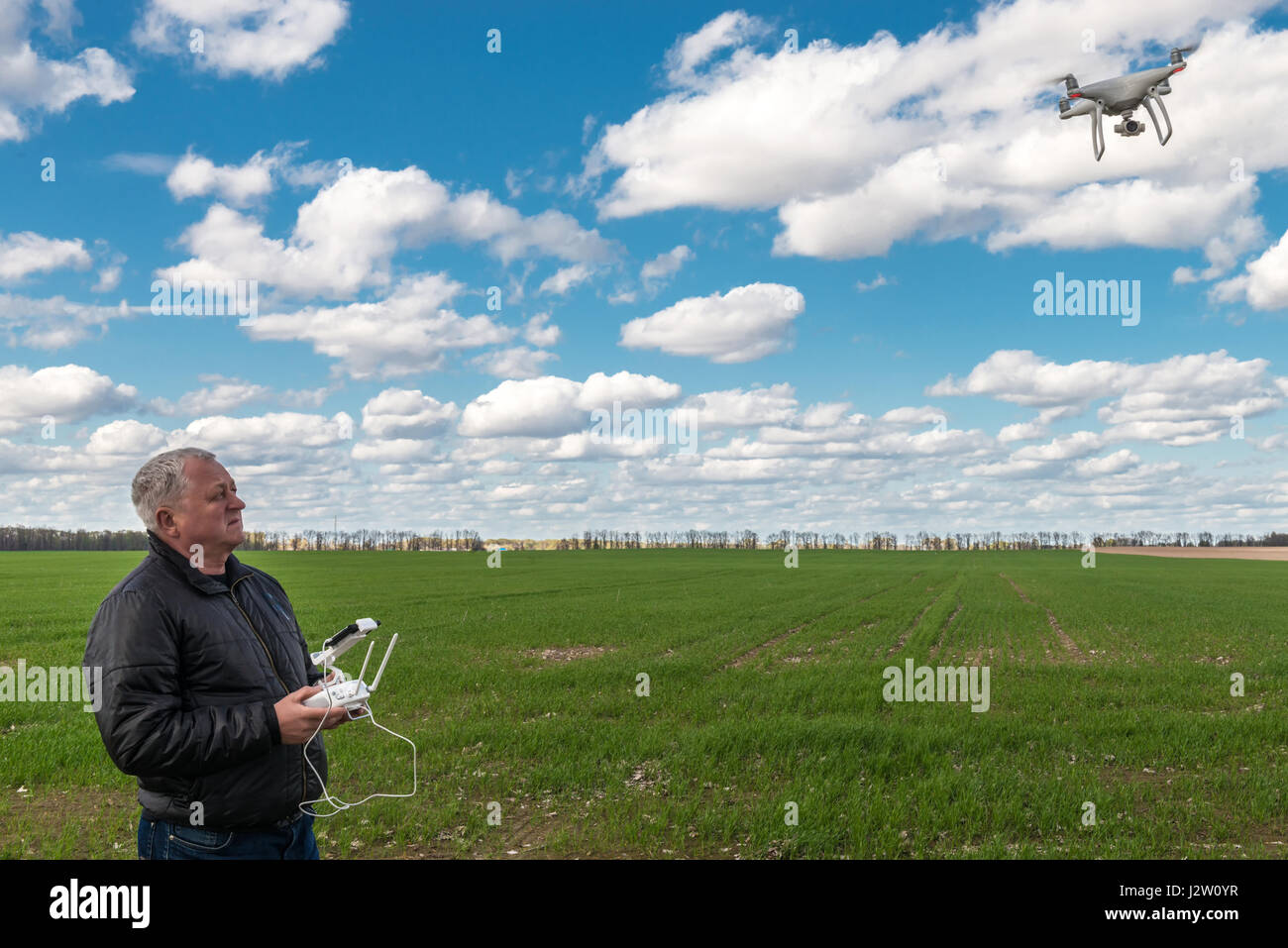 L'uomo gioca con il drone in corrispondenza del campo verde Foto Stock