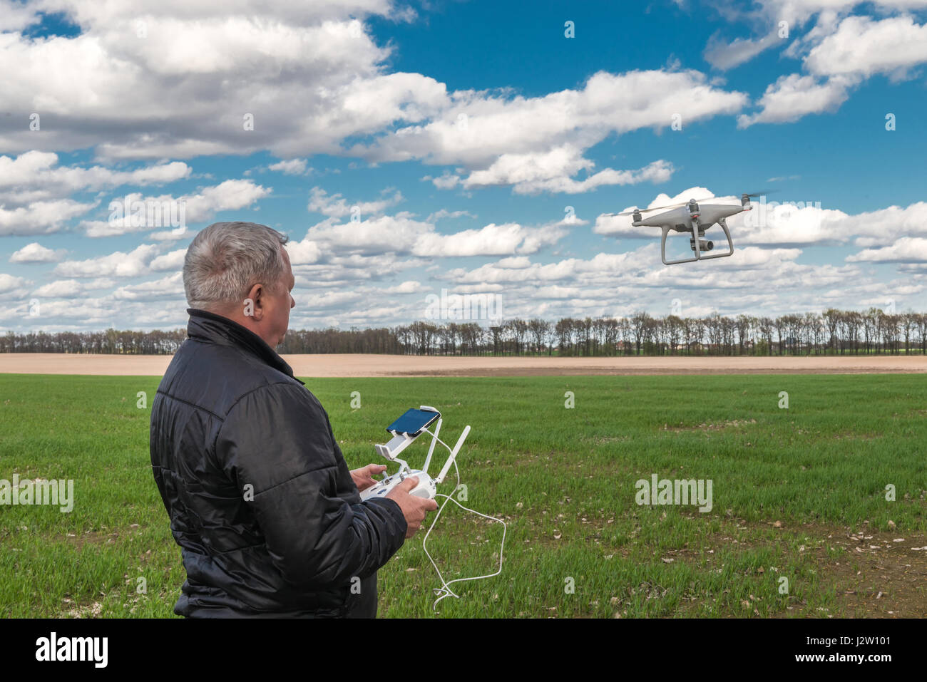 L'uomo gioca con il drone in corrispondenza del campo verde Foto Stock