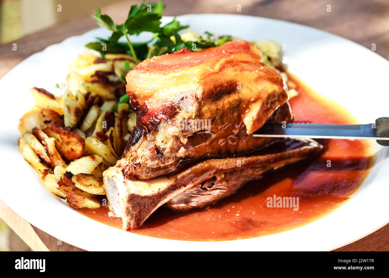Tradizionale arrosto di maiale Schaeufele stile di Monaco di Baviera con patate fritte Foto Stock
