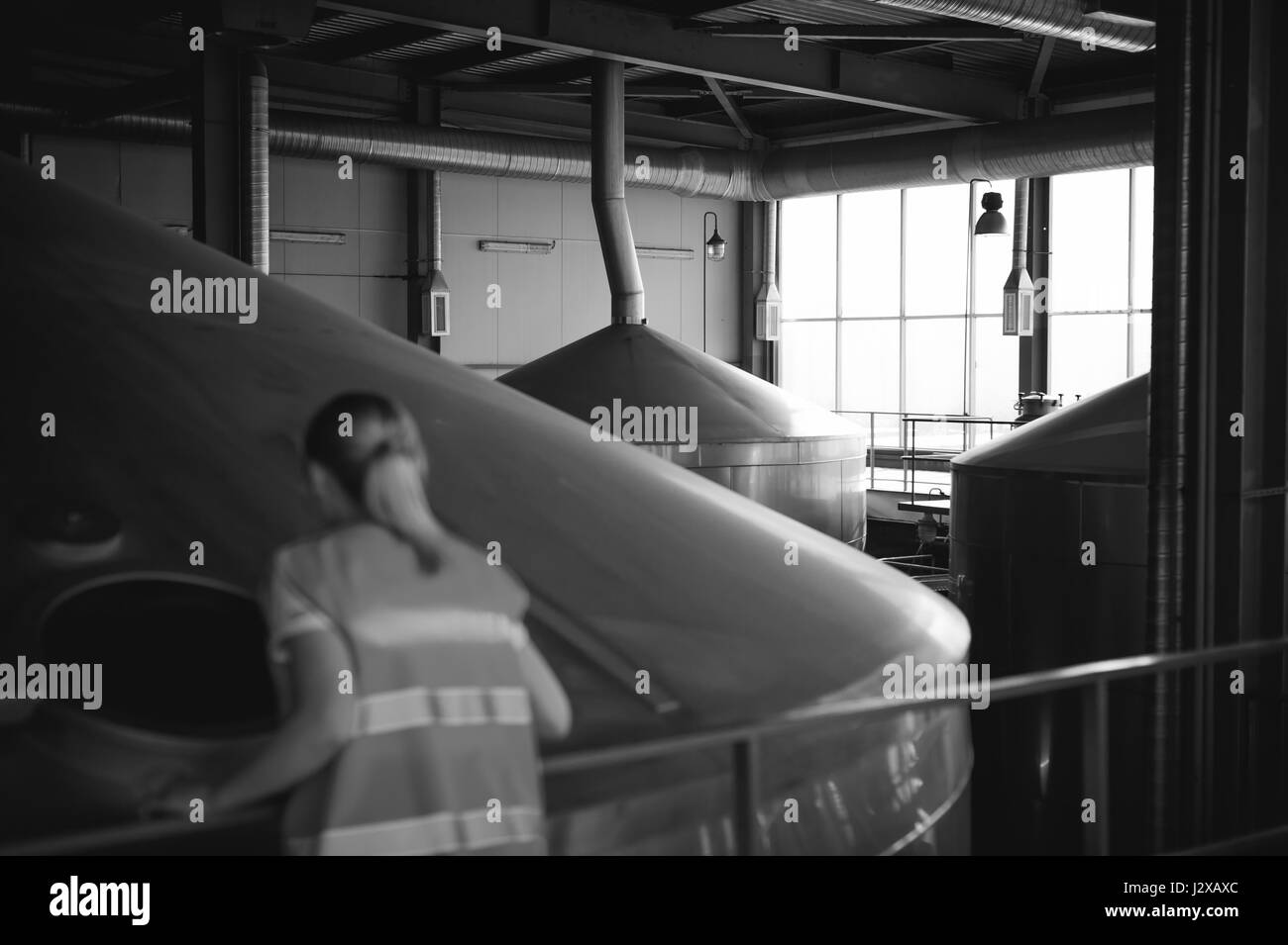 Lavoratore di sesso femminile che sulla fabbrica di birra. ritratto donna in accappatoio, permanente sulla linea di sfondo della produzione alimentare, il controllo di gestione di apparecchiature di controllo per il processo di produ Foto Stock