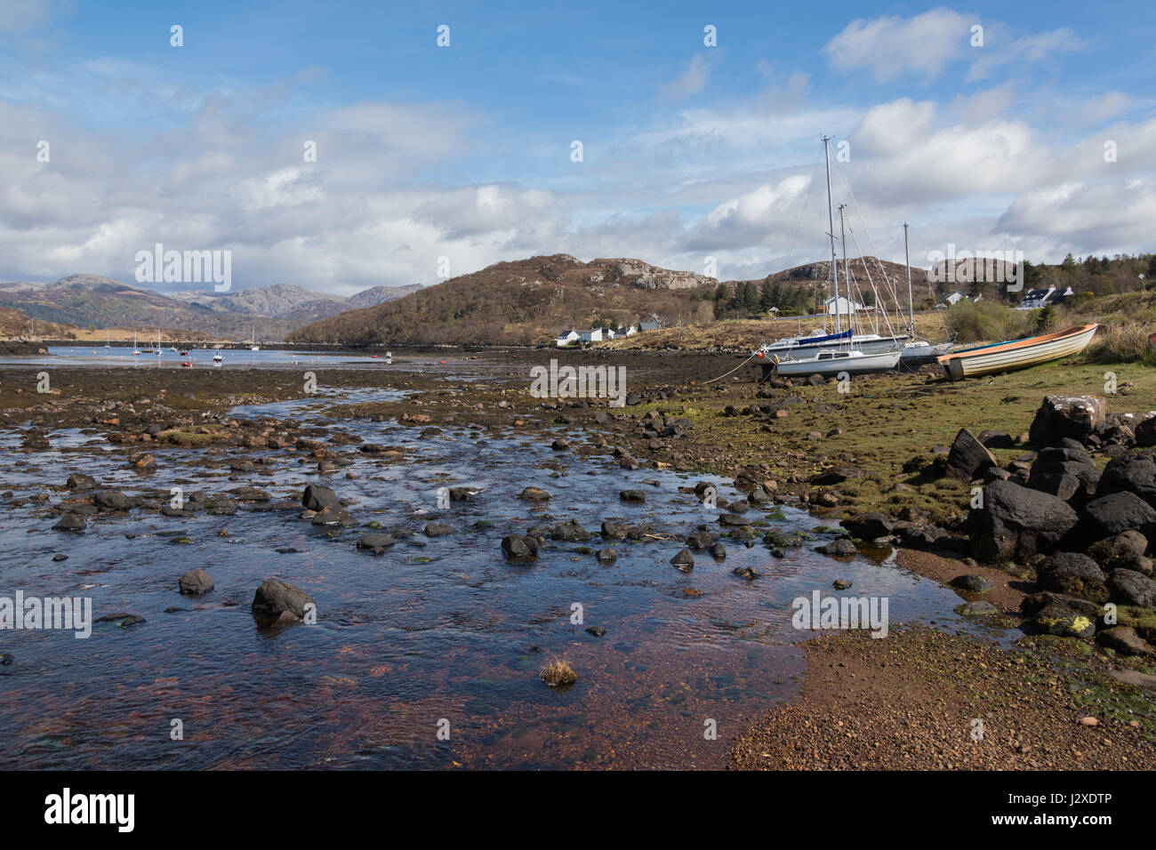 Barche a ancora presso l'ex villaggio di pescatori di Badachro, nelle Highlands occidentali del nord della Scozia Foto Stock