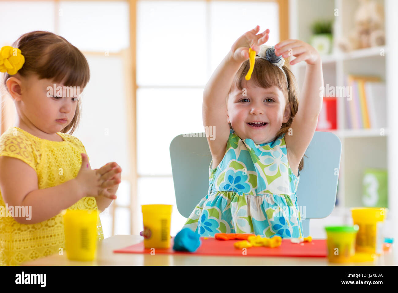 I bambini divertendosi insieme con colorati di creta per modellare assistenza diurna a. Bimbi creativi lo stampaggio a casa. I bambini le ragazze giocare con la plastilina o la pasta. Foto Stock