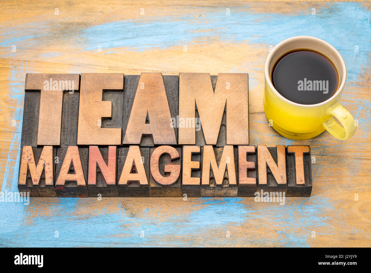 Gestione dei team banner in rilievografia vintage tipo di legno con una tazza di caffè Foto Stock