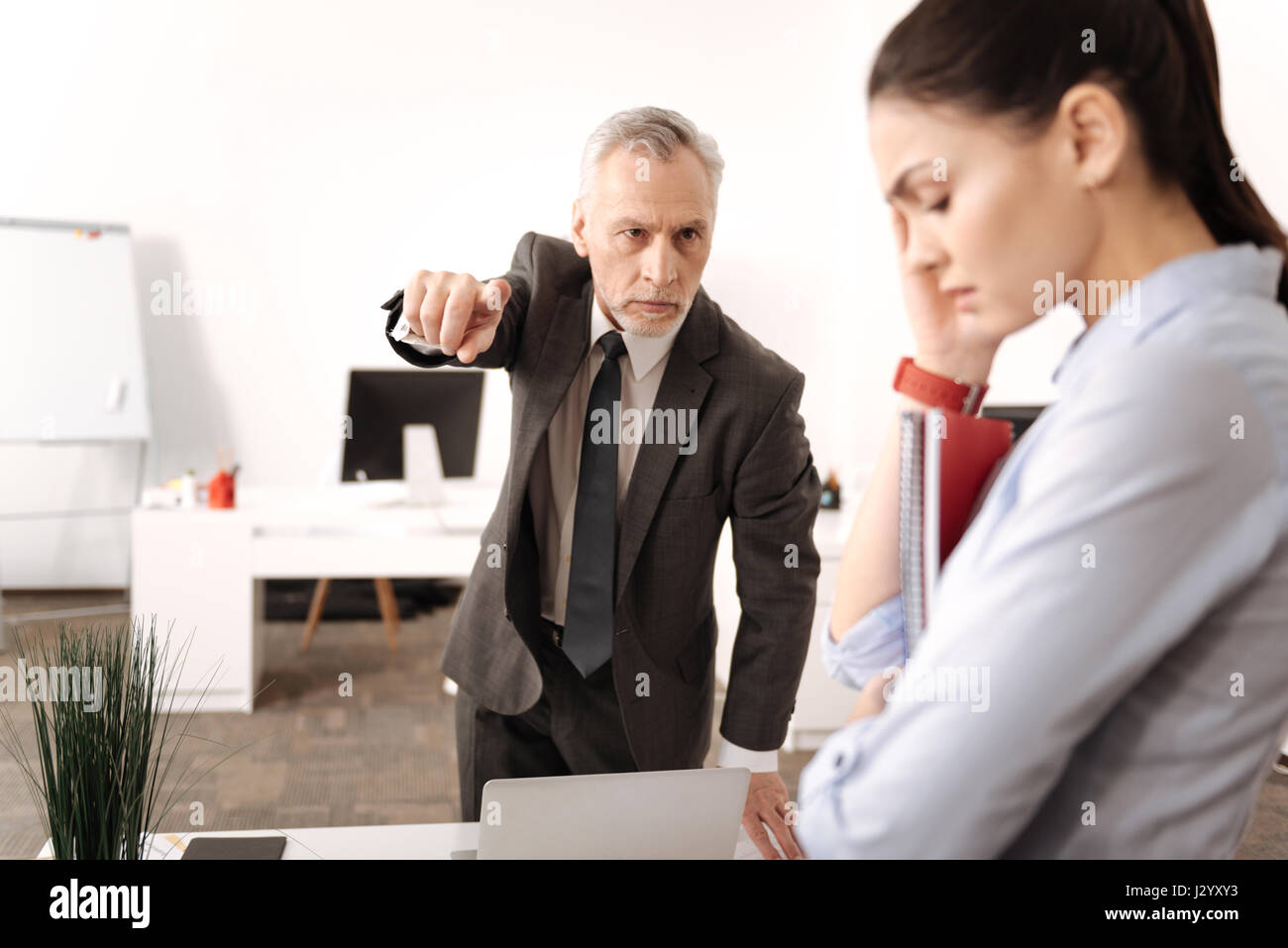 Ritratto di rigorosa capo azienda mantenendo la mano in aria Foto Stock