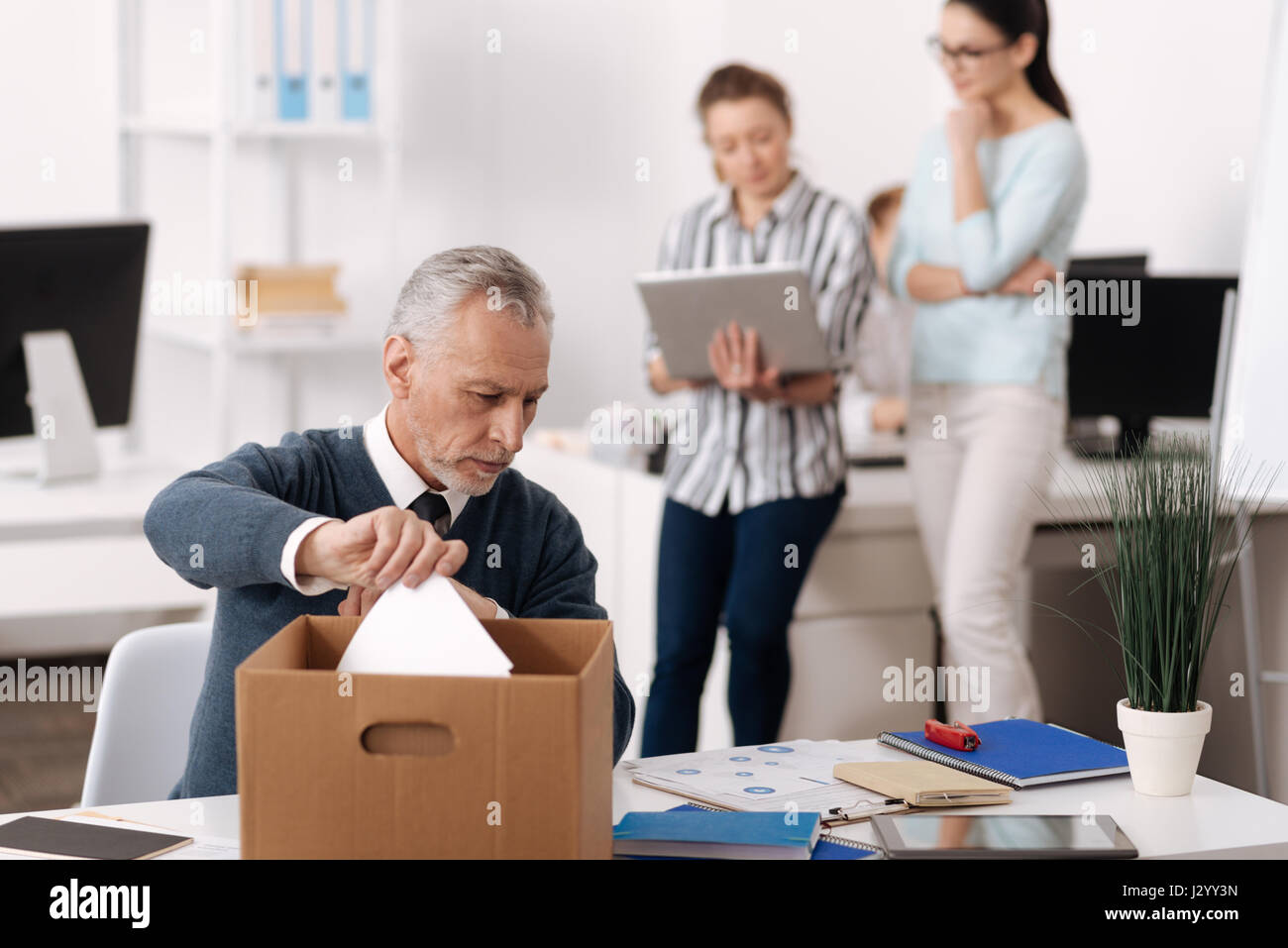 Attento persona maschile seduto al suo posto di lavoro Foto Stock