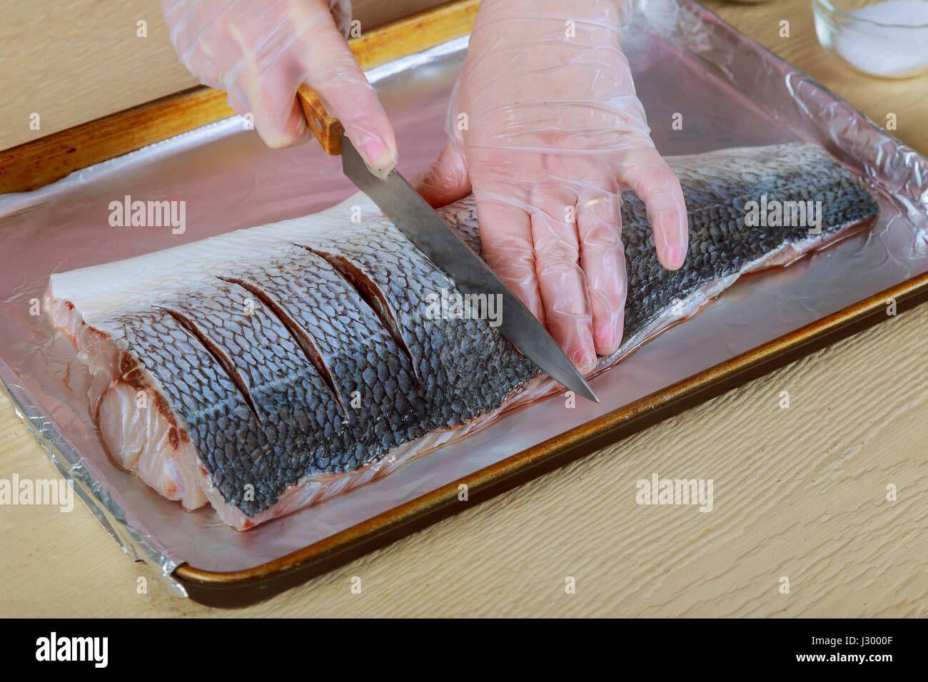 Donna di filetto marinato pesce pesce crudo su cucina cipolla piatto in forno Foto Stock